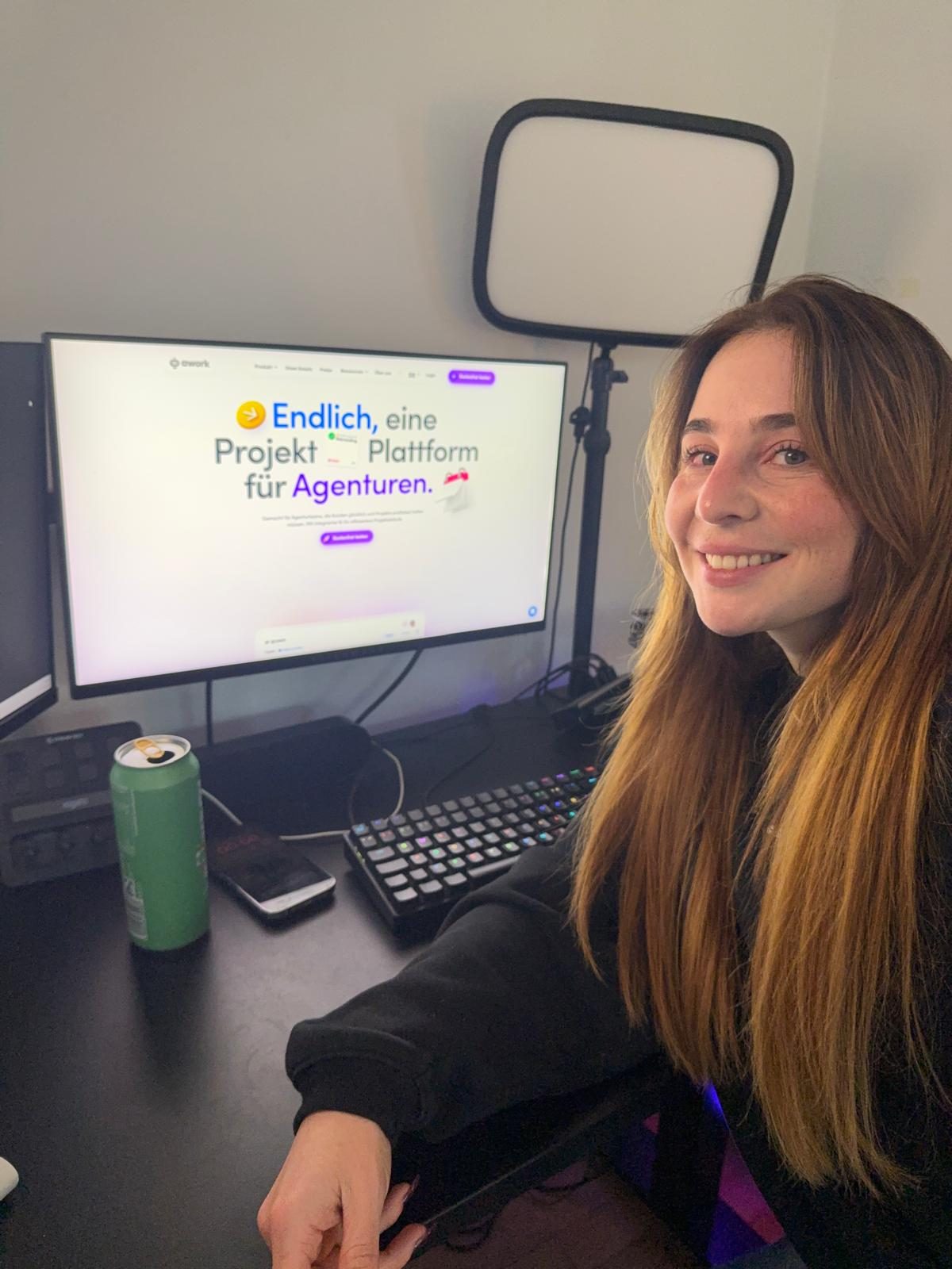 Verena an ihrem Setup, auf dem Monitor die awork-Website — Projektplattform für Agenturen